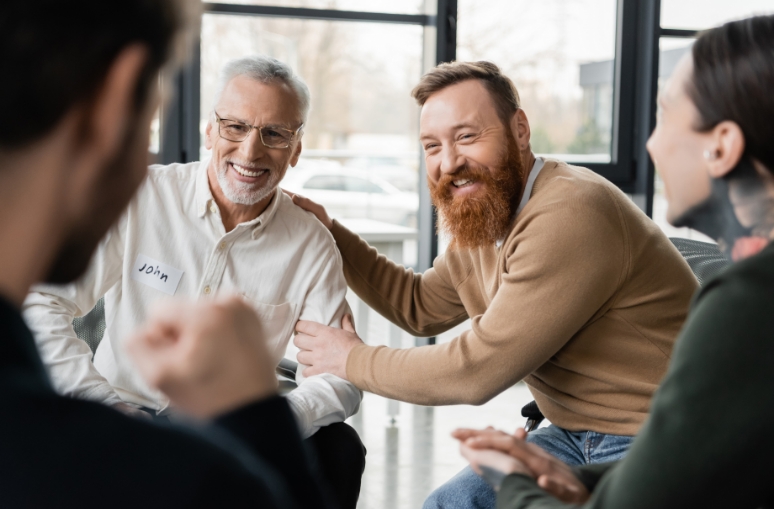 A group of people in the Coping Club gather and share a friendly conversation at Waypoint.
