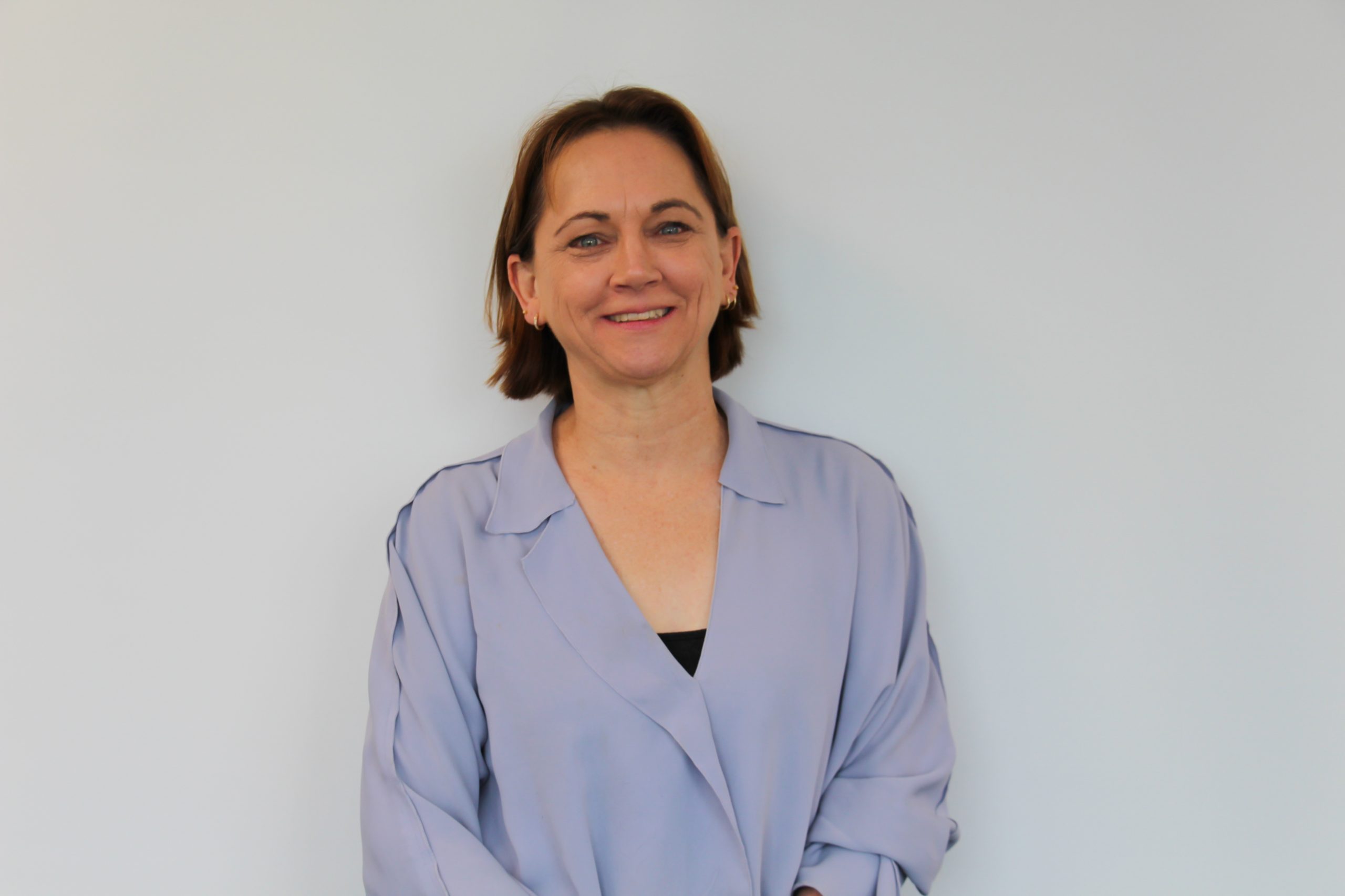 Dr. Carolyn Houlding smiling in front of a white background.