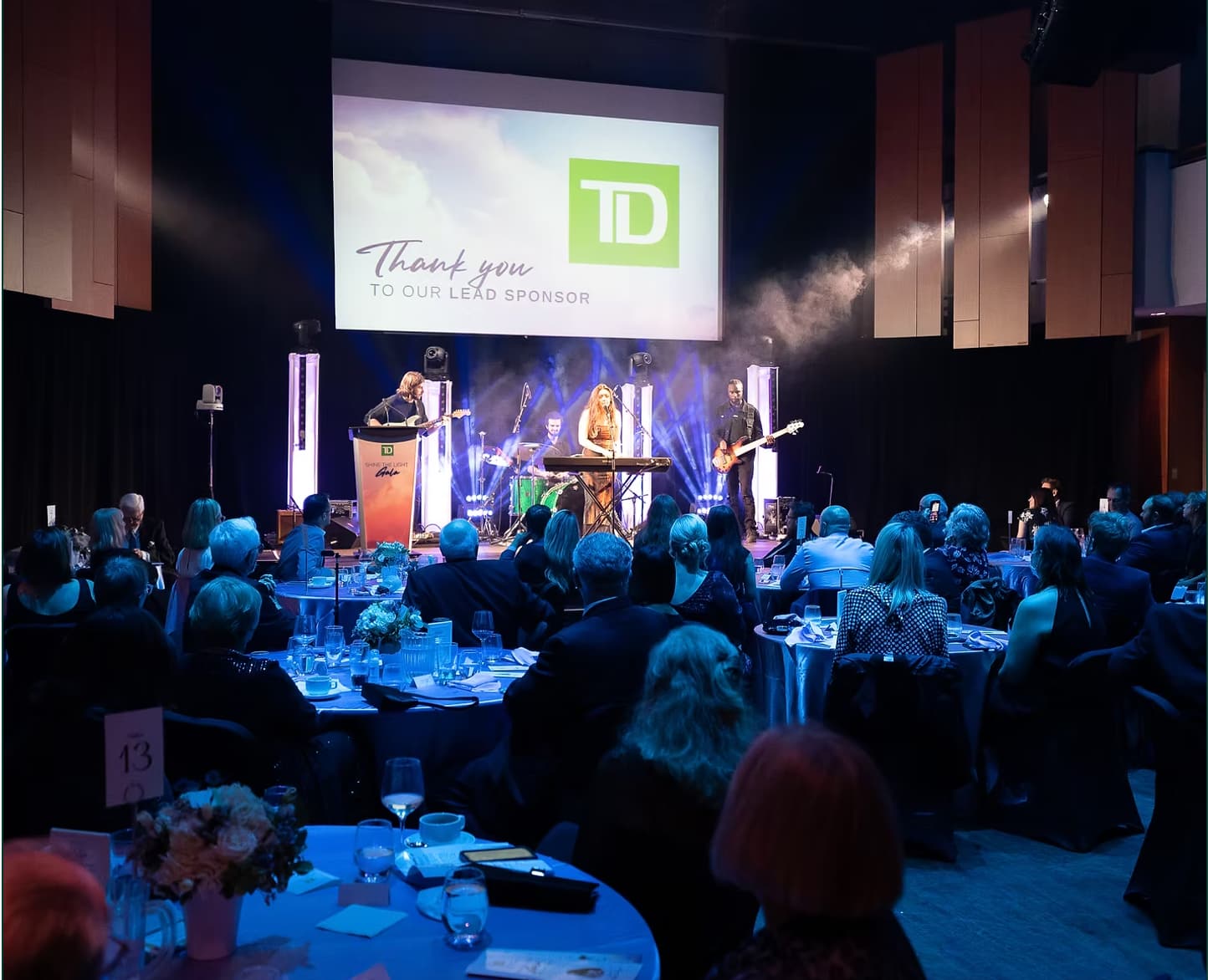 A band plays in front of a seated gala crowd.