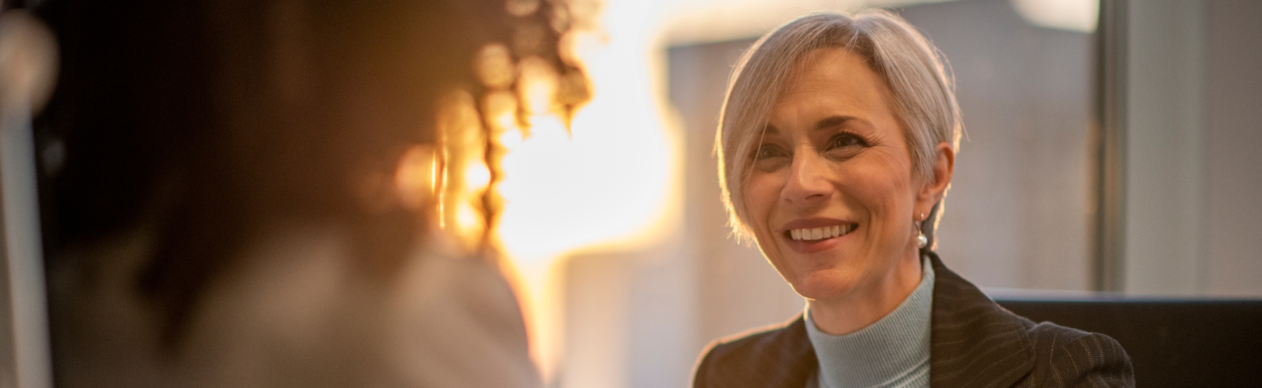 a woman smiling at another person.