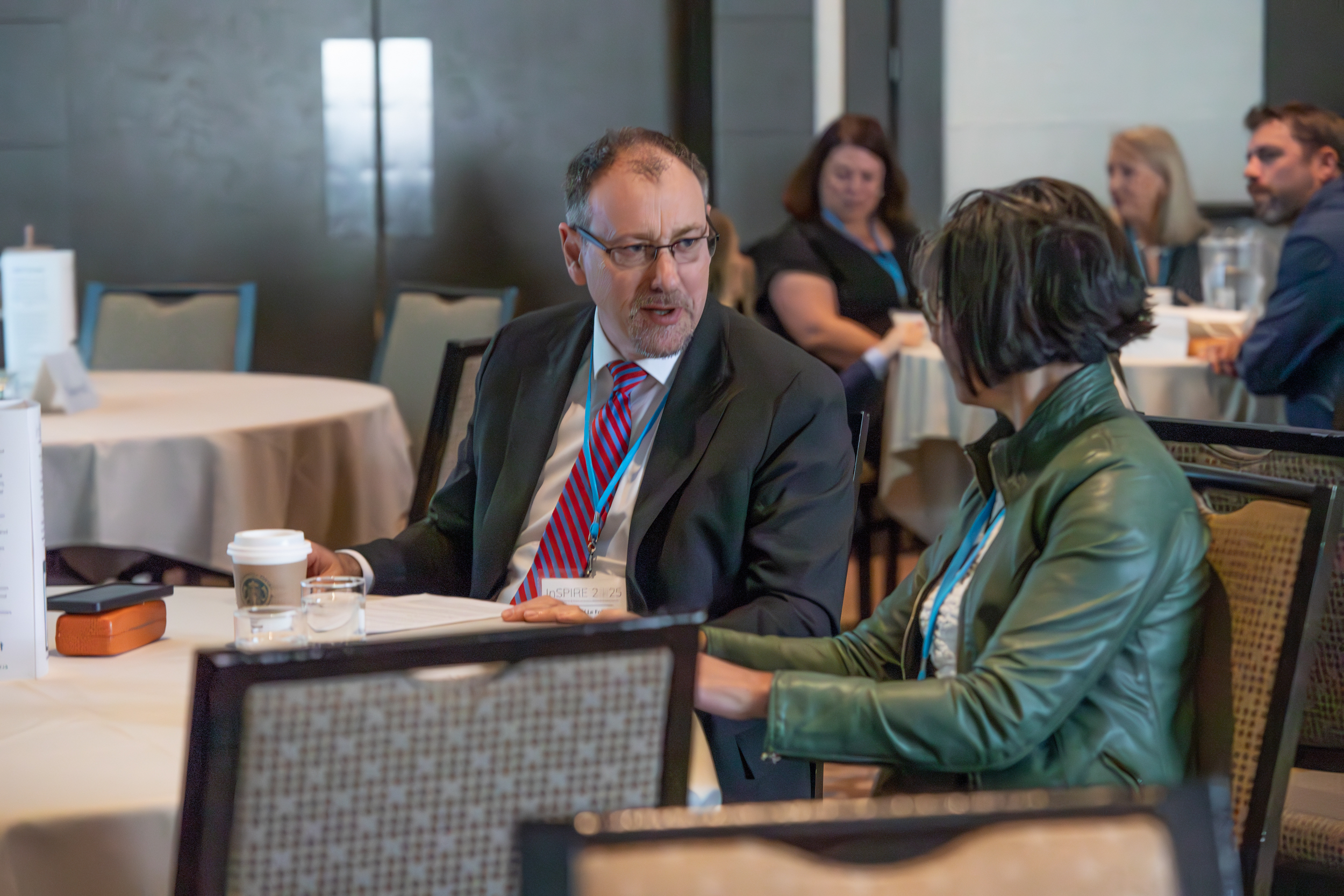 Dr. Sunderji and Dr. La Foll chatting at a table