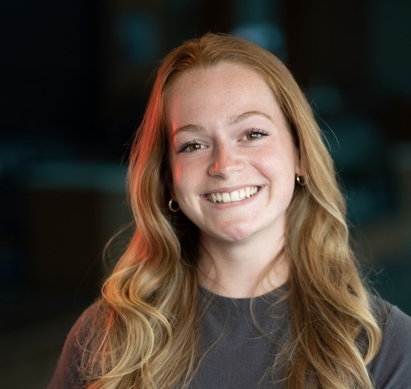 Ella smiling in front of dark background