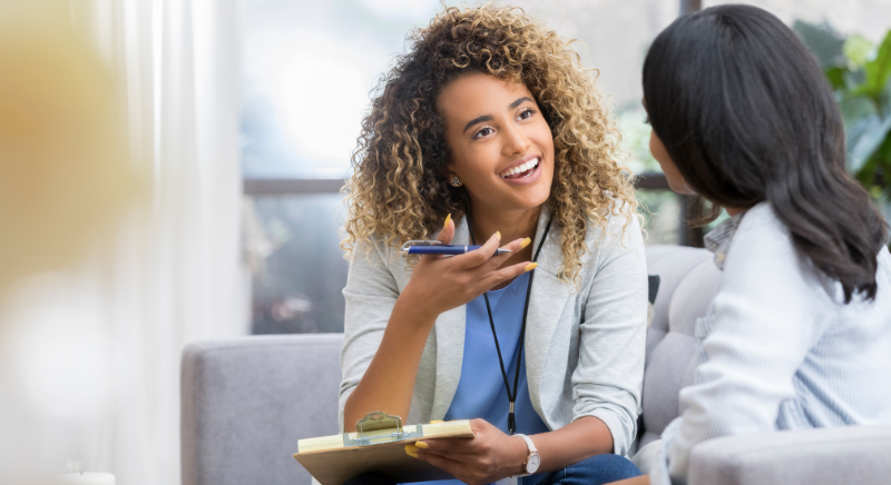 Two women speaking to eachother on a couch