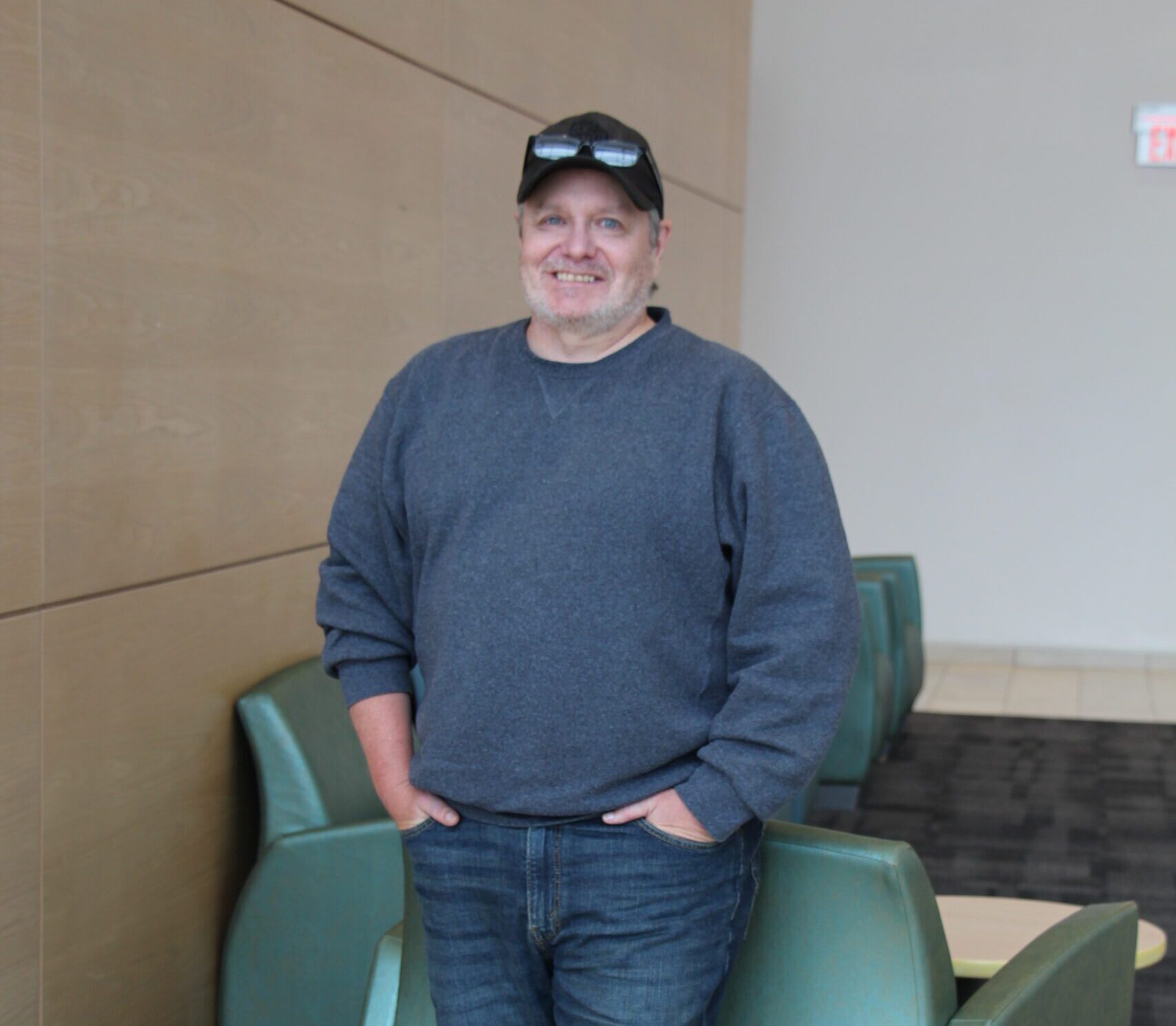 Andrew Shields posing in front of a chair