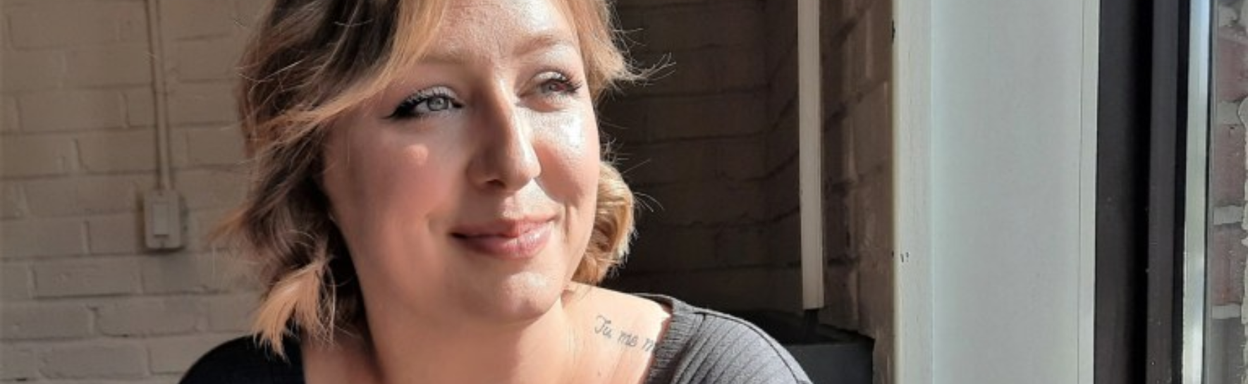 Ashley looking out a window with the sun on her face