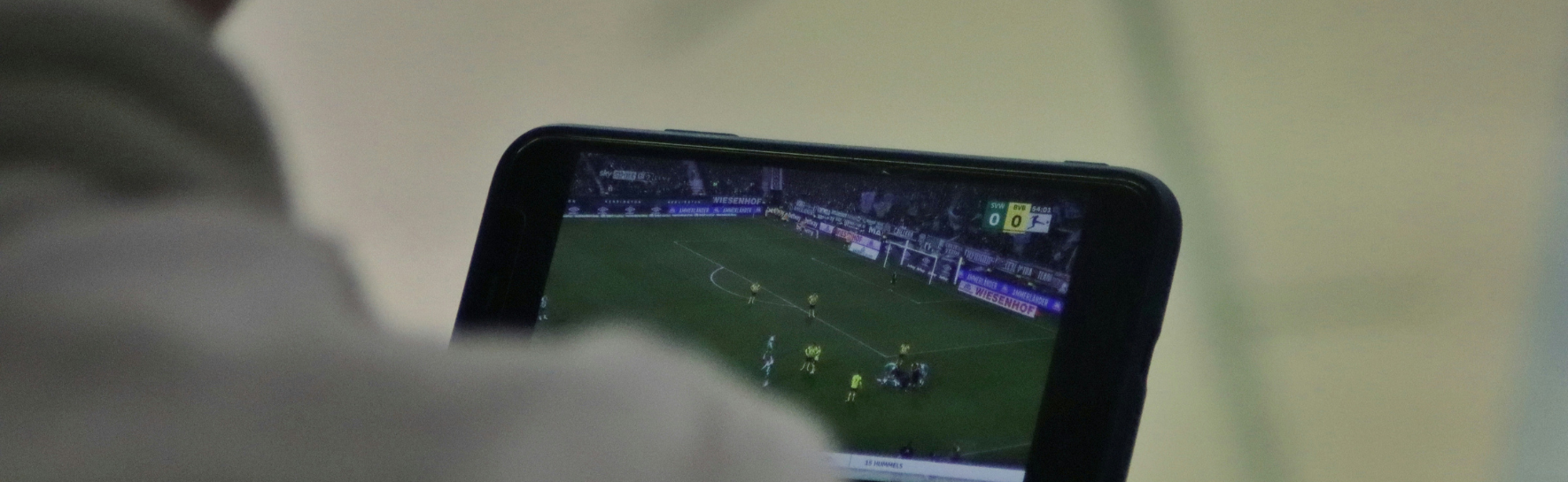 a person looks at a sports game on their phone.