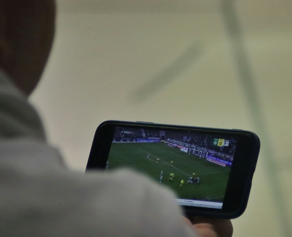 A person looks at a sports game on a tablet