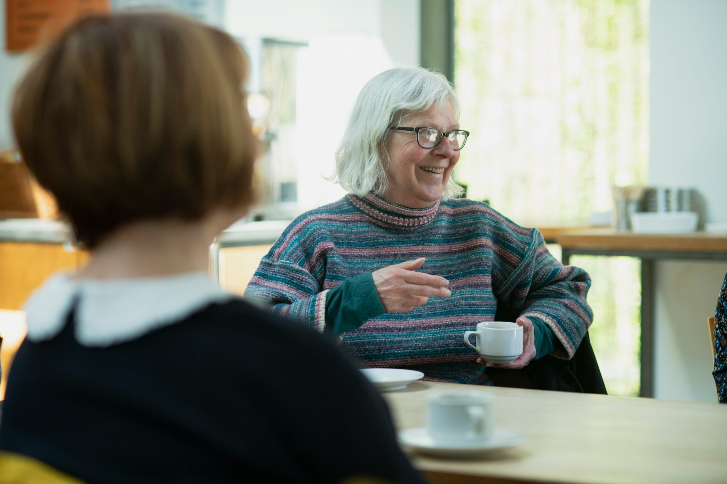 Woman holding coffee laughing