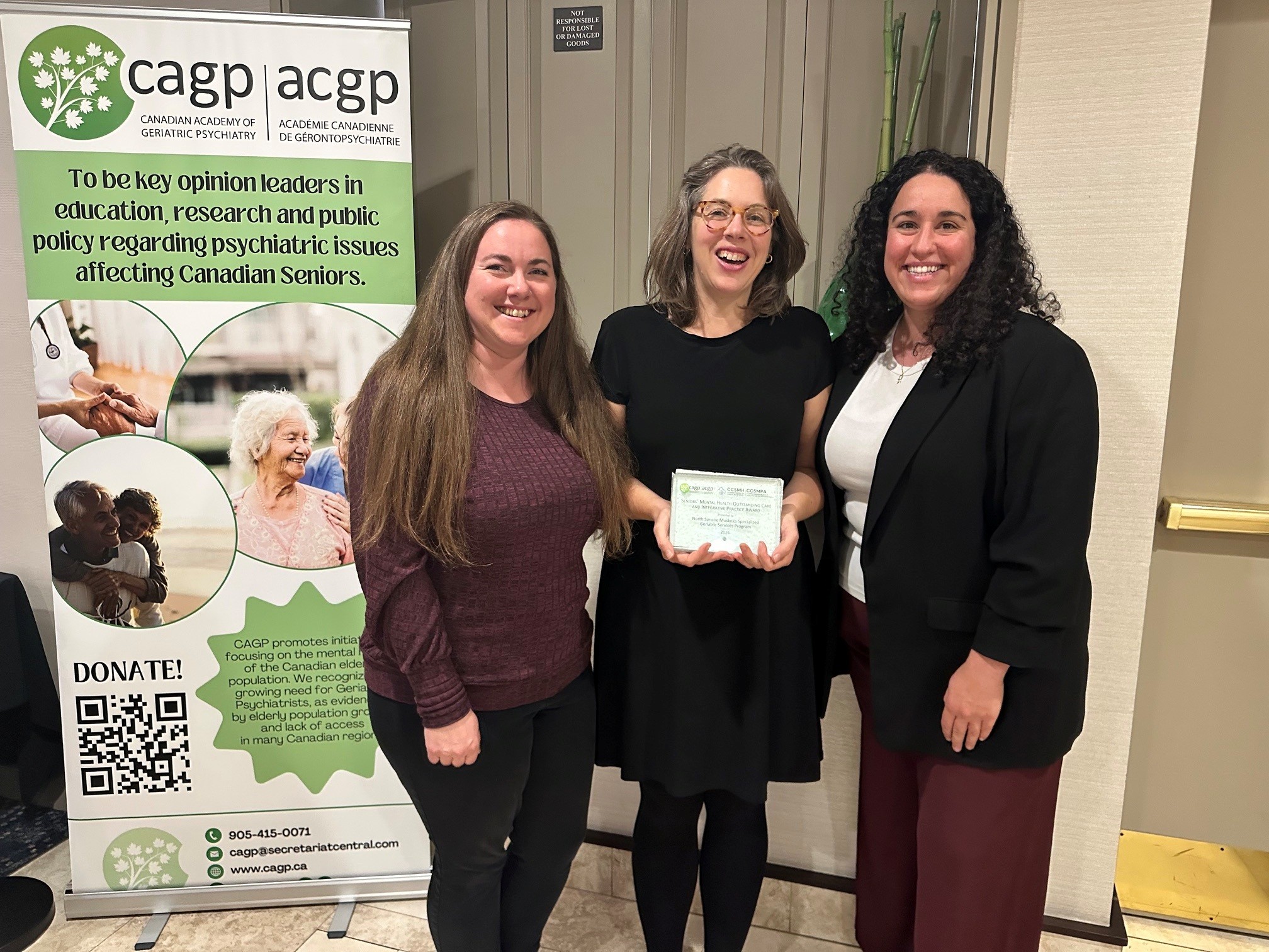 Three NSMSGS team members show the Seniors’ Mental Health Award plaque